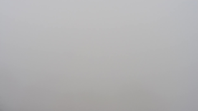 A featureless gray image indicating dense fog, with no discernible shapes or colors, creating a uniform and indistinct visual effect.