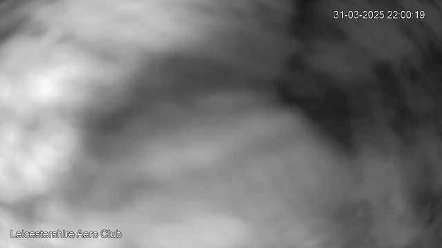 A blurred, monochromatic image shows indistinct shapes and textures, suggesting an abstract view of the sky or clouds. In the bottom left corner, the text "Leicestershire Aero Club" is visible, with a timestamp in the upper right corner indicating "31-03-2025 22:00:19." The overall tone is dark and lacks clear details.