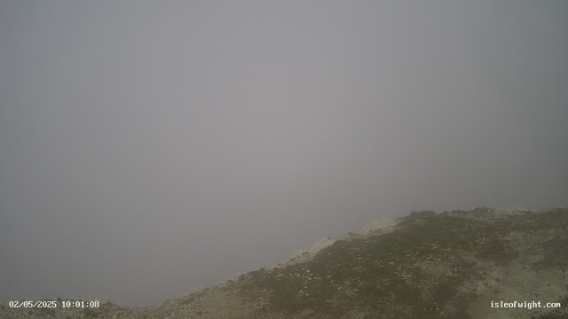 A foggy landscape with a trail or path on a hillside, partially covered by the fog. The ground appears rocky with sparse vegetation. The scene is very obscured by the fog, limiting visibility. The timestamp indicates the photo was taken on February 5th, 2025 at 10:01 AM.