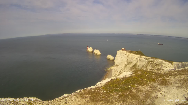 A panoramic view of white chalk cliffs along the coastline, with a lighthouse on a small rocky island formation. The sea is calm, and several small sailboats and a larger cargo ship can be seen in the distance under a partly cloudy sky. The timestamp indicates the photo was taken on May 20, 2023, at 10:01:03.