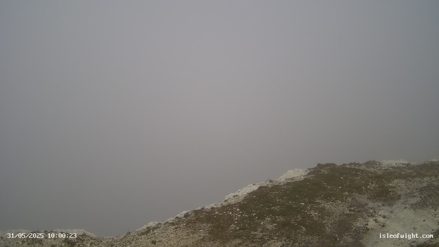 A foggy landscape with a rocky, uneven terrain in the foreground. The sky is overcast and visibility is low due to the dense fog. The photo appears to be taken from a high elevation, possibly on a mountain or hill. The date and time stamp is 31/05/2025 at 10:00:23.