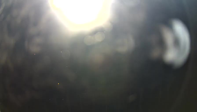 The image appears to be a blurry webcam shot with bright light source at the top, causing overexposure in that area. The image is dark and indistinct, with no clear objects or details visible.